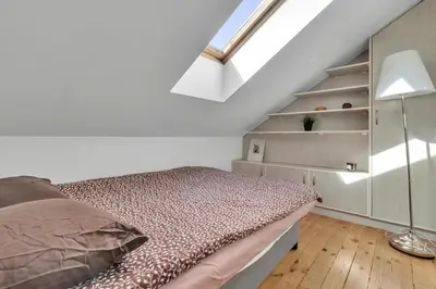 a white bedroom with a bed and a staircase at Vilnius Old Town Amber Penthouse in Vilnius