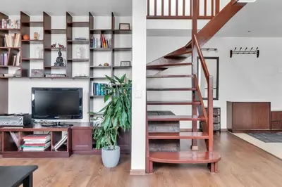 a living room with a staircase and a television at Vilnius Old Town Amber Penthouse in Vilnius