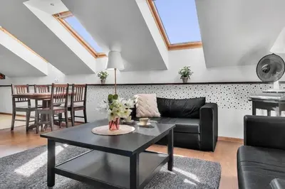 a living room with a black couch and a table at Vilnius Old Town Amber Penthouse in Vilnius
