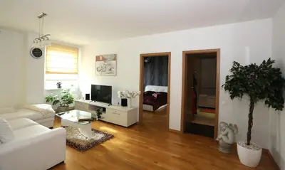 a living room with a white couch and a tv at Apartamentai Panevezys in Panevėžys