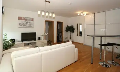 a living room with a white couch and a table at Apartamentai Panevezys in Panevėžys