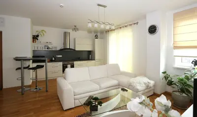 a living room with a white couch and a table at Apartamentai Panevezys in Panevėžys
