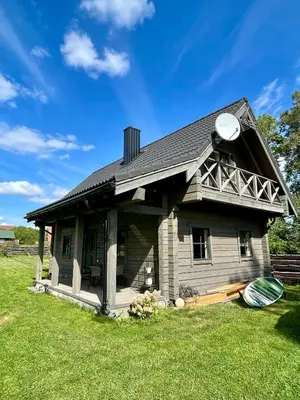 a small house sitting on top of a lush green field at Cozy House by Galuonai Lake - Jauki 3 miegamųjų sodyba 200 m nuo Galuonų ežero in Inturkė