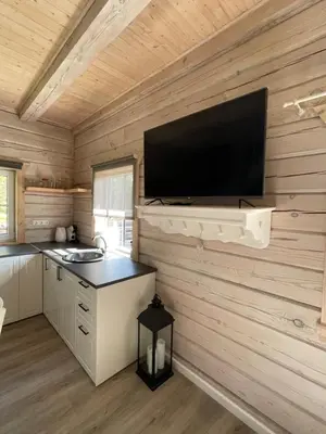 a kitchen with a flat screen tv on a wall at Cozy House by Galuonai Lake - Jauki 3 miegamųjų sodyba 200 m nuo Galuonų ežero in Inturkė