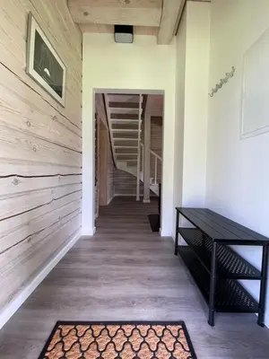 a hallway with a table and a rug at Cozy House by Galuonai Lake - Jauki 3 miegamųjų sodyba 200 m nuo Galuonų ežero in Inturkė