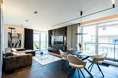 a living room with a table and chairs and a television at Castle Town Kaunas Apartaments in Kaunas