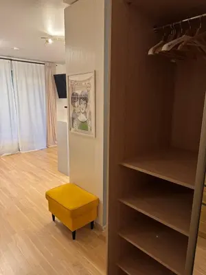 a closet with a yellow ottoman in a room at Cozy Ozo Park Apartment, Pet Friendly with Workspace in Vilnius