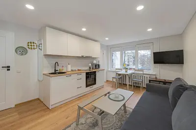 a kitchen and living room with a couch and a table at Apartment Lampėdis by Polo Apartments in Kaunas