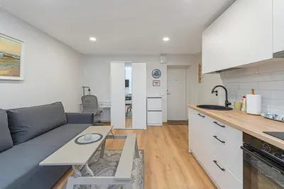 a kitchen and living room with a couch and a table at Apartment Lampėdis by Polo Apartments in Kaunas
