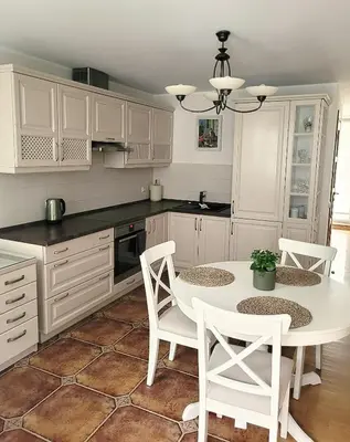 a kitchen with white cabinets and a table and chairs at Maironio 21A apartments - City center - Free parking in Kaunas