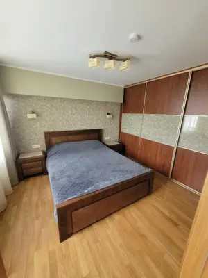 a bedroom with a bed and wooden floors at Maironio 21A apartments - City center - Free parking in Kaunas