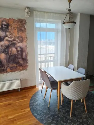 a dining room with a table and chairs and a painting at kabantys sodai in Vilnius