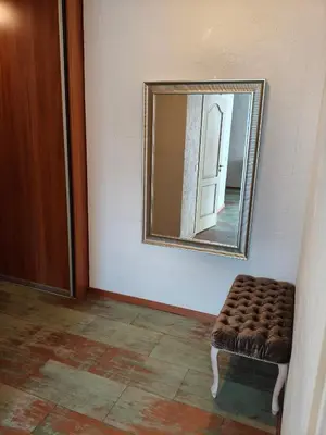 a room with a mirror and a stool in front of a door at kabantys sodai in Vilnius