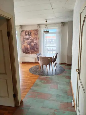 a dining room with a table and chairs and a painting at kabantys sodai in Vilnius