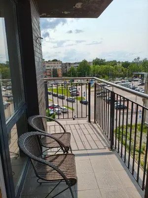 a balcony with two chairs and a view of a street at kabantys sodai in Vilnius