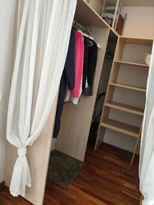 a walk in closet with a curtain over the door at kabantys sodai in Vilnius