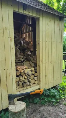 a woodenshed with a pile of logs in it at Hunters Lounge Apartments