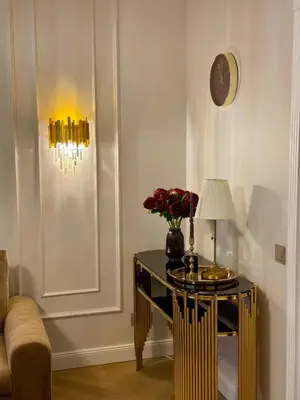 a room with a table with a lamp and flowers on it at KR Apartment Kaunas in Kaunas