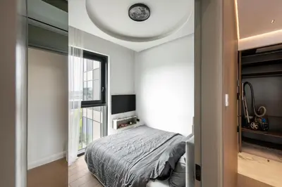 a bedroom with a bed and a clock on the wall at Sky&River Towe Apartments Kaunas City Center in Kaunas