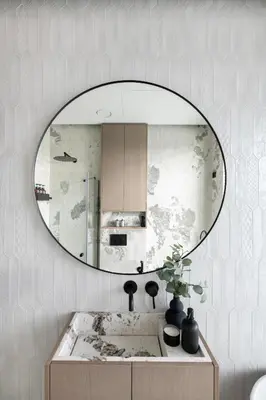 a mirror on a wall above a bathroom sink at Sky&River Towe Apartments Kaunas City Center in Kaunas
