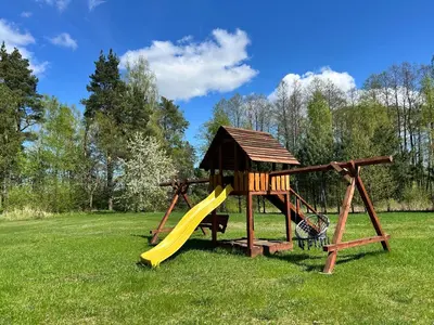 a playground with a slide and a play structure at Pasienio krantas in Velūnai