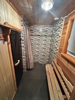 a walk in shower in a room with a bench at Pasienio krantas in Velūnai