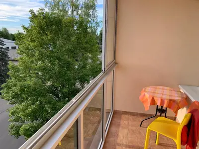 a balcony with a table and yellow chairs and a window at Mineral Apartment in Druskininkai