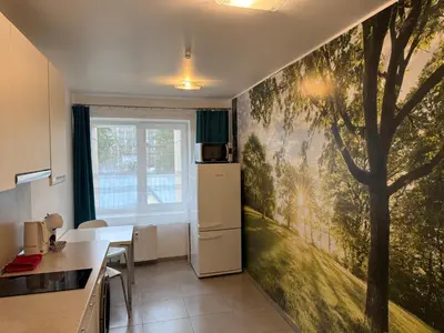 a kitchen with a tree painting on the wall at Mineral Apartment in Druskininkai