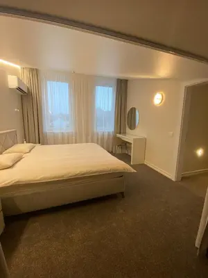 a bedroom with a bed and a desk and windows at Modern Loft Apartment with free parking No4 in Marijampolė