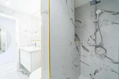 a bathroom with a shower and a toilet and a sink at Modern Loft Apartment with free parking No4 in Marijampolė