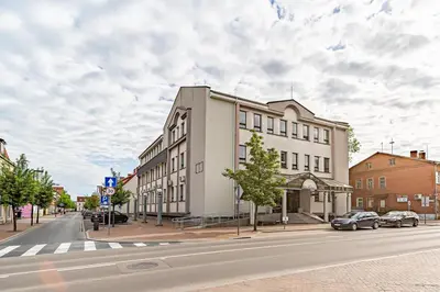 a building on a street with cars parked on the street at Modern Loft Apartment with free parking No4 in Marijampolė