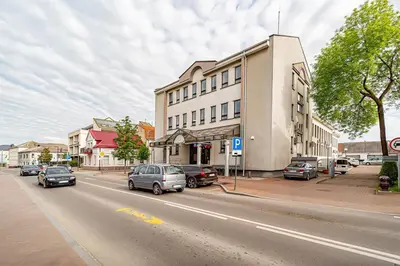 a street with cars parked in front of a building at Modern Loft Apartment with free parking No4 in Marijampolė