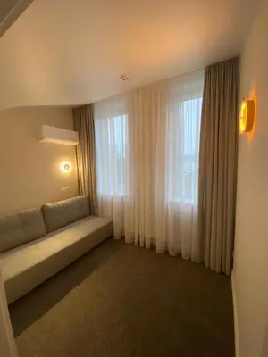 a living room with a couch in front of a window at Modern Loft Apartment with free parking No4 in Marijampolė