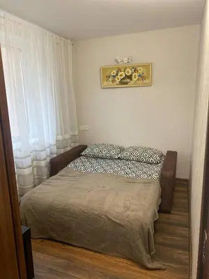 a small bedroom with a bed and a window at Butas Čiurlionio gatvėje in Pakopi
