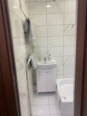 a white bathroom with a sink and a tub at Butas Čiurlionio gatvėje in Pakopi