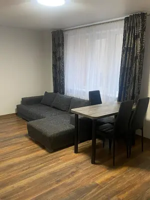 a living room with a couch and a table and chairs at Butas Čiurlionio gatvėje in Pakopi