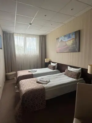 a hotel room with two beds and a painting on the wall at Naujamiescio Studio 305 in Vilnius
