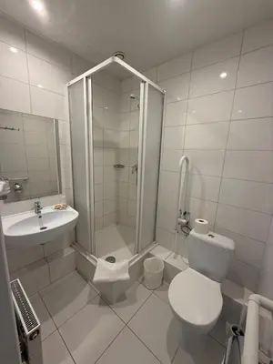 a white bathroom with a shower and a toilet at Naujamiescio Studio 305 in Vilnius