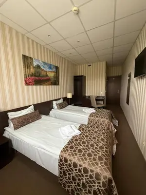a hotel room with two beds and a television at Naujamiescio Studio 305 in Vilnius
