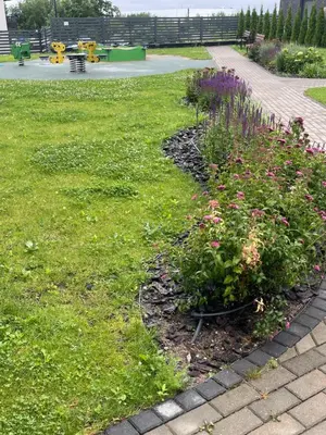 a garden with flowers in the grass in a park at Family room in Vilnius