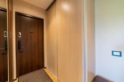 a hallway with a wooden door in a room at Blue Sky Apartments in Šiauliai