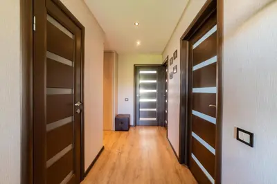 a hallway with two doors and a suitcase at Blue Sky Apartments in Šiauliai