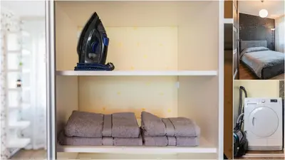 a room with a shelf with a bed and a microwave at Blue Sky Apartments in Šiauliai