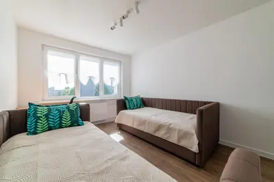 a living room with a couch and a window at Blue Sky Apartments in Šiauliai