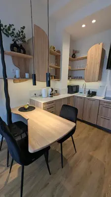 a kitchen with a wooden table and chairs at Kaunas City Centre Apartment Self Check-In & AC in Kaunas