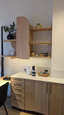 a kitchen with wooden cabinets and a counter top at Kaunas City Centre Apartment Self Check-In & AC in Kaunas