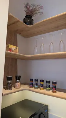 a shelf with wine glasses and vases on it at Kaunas City Centre Apartment Self Check-In & AC in Kaunas