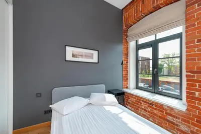 a bedroom with a bed and a brick wall at Shanti barracks apartment #3 by Polo Apartments in Kaunas