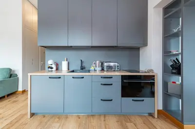 a kitchen with blue cabinets and a counter top at Shanti barracks apartment #3 by Polo Apartments in Kaunas