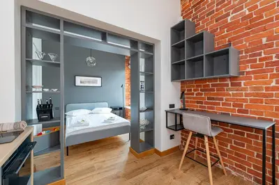 a room with a brick wall and a bedroom at Shanti barracks apartment #3 by Polo Apartments in Kaunas